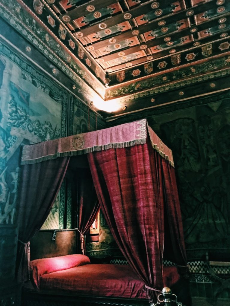 The red velvet canopy bed of the royal bedroom in Alcázar. 